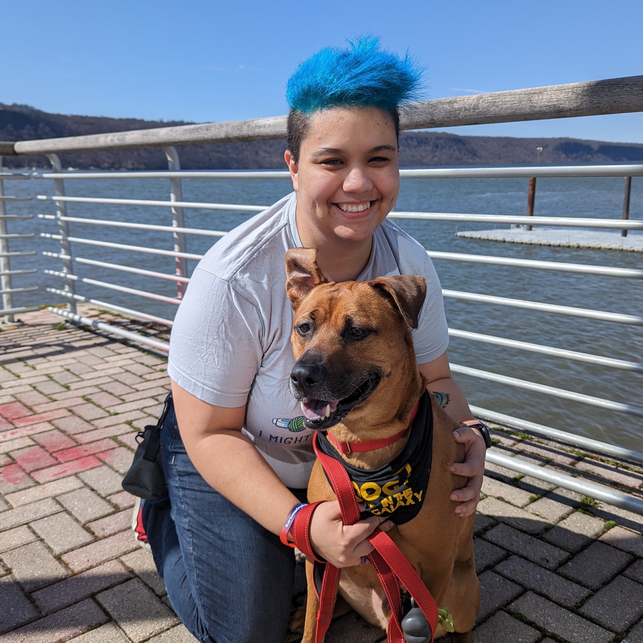 Lin on a pier holding a dog.