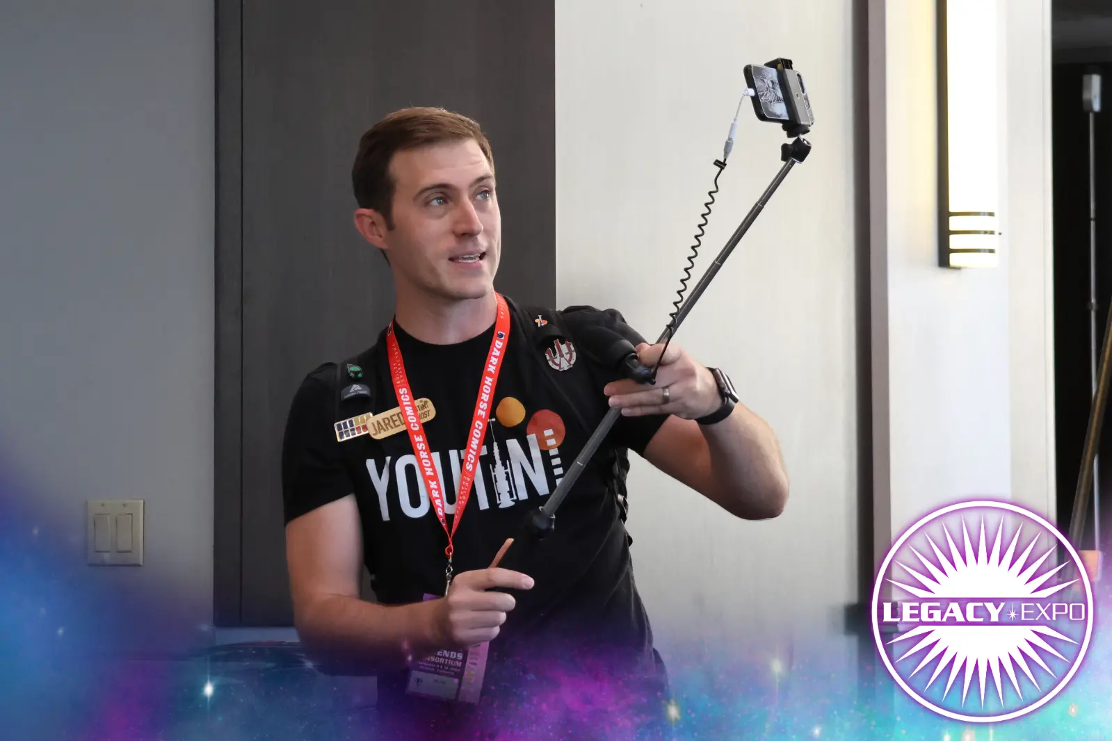 A media badge holder recording on his phone.