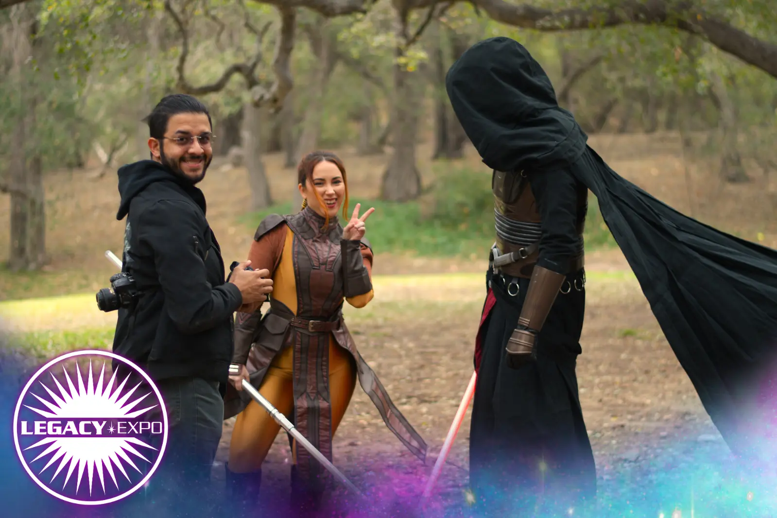 A photographer, a Bastila cosplayer and a Darth Revan cosplayer posing for a picture.